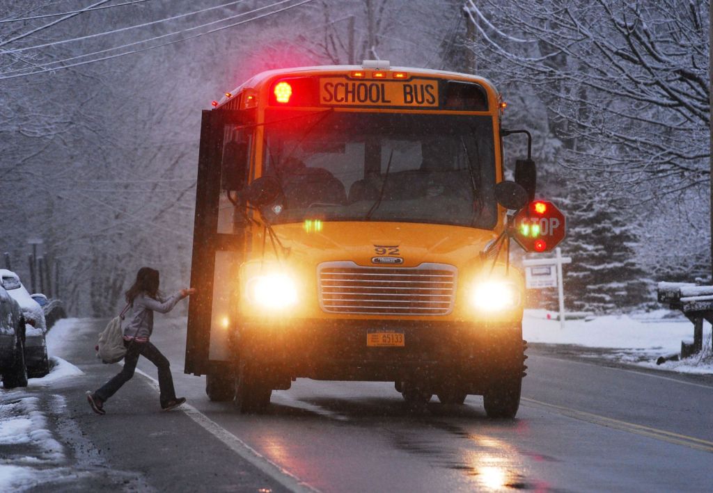 A child boarding a school bus on a snowy morning